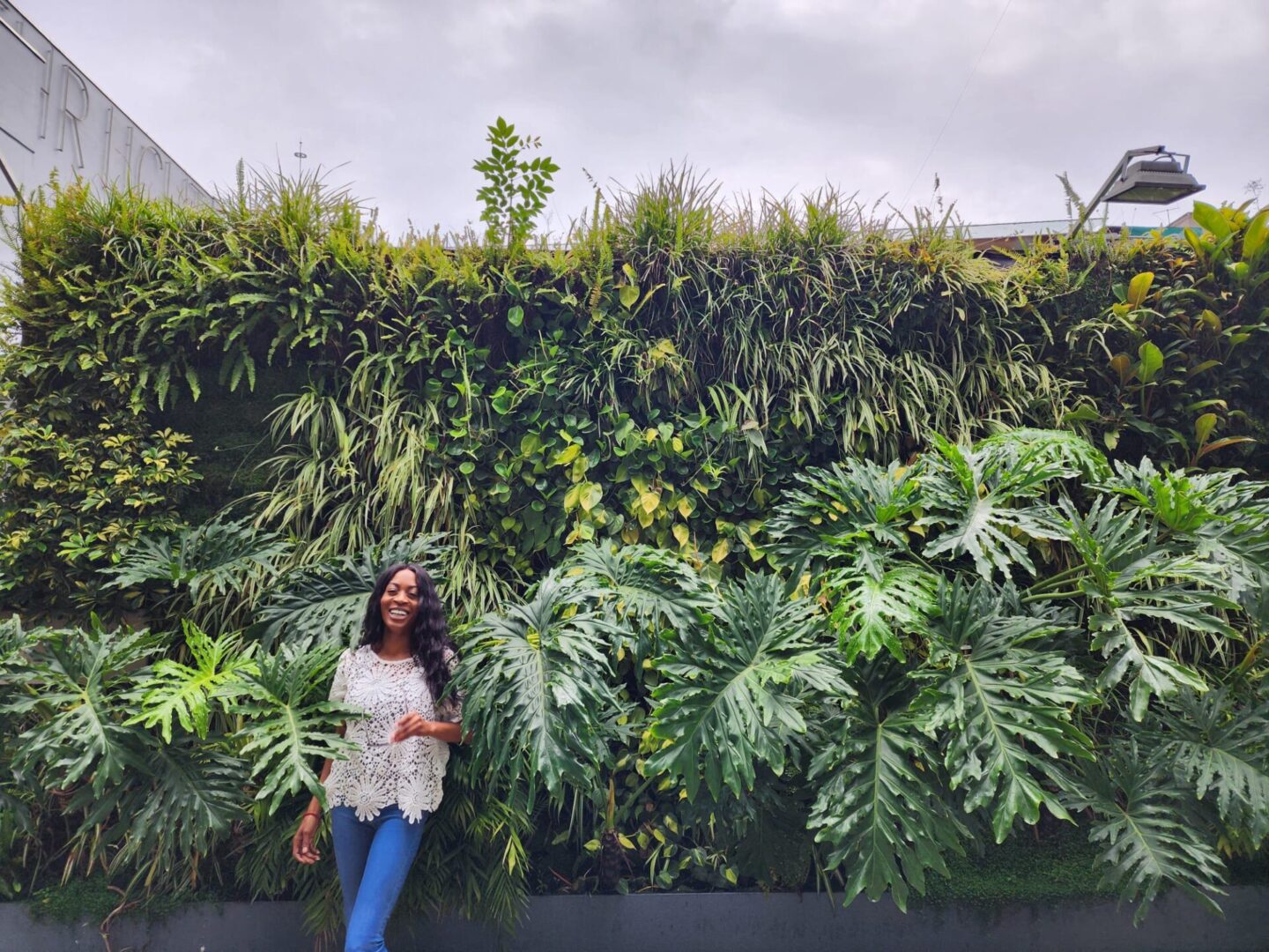 Woman smiles by vibrant green wall.