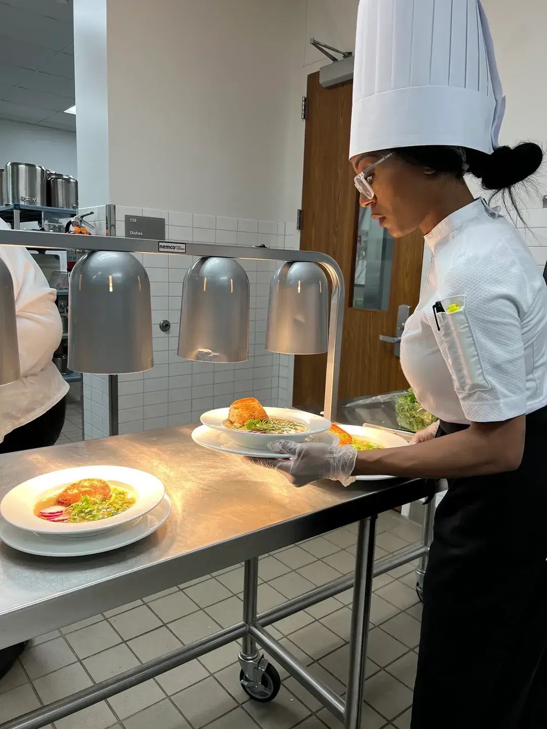 Chef plating gourmet soup dishes.